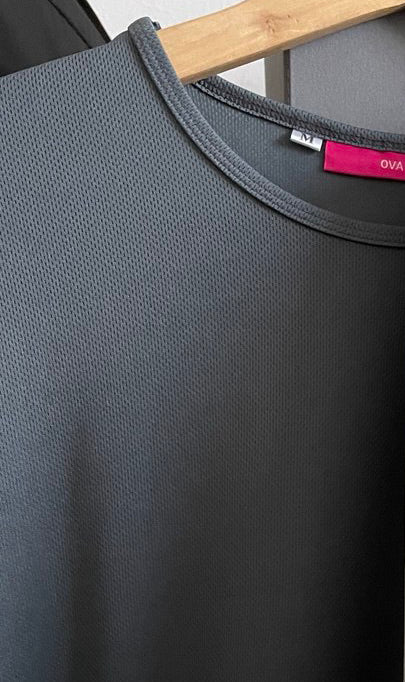 Gray dry fit t-shirt with a brand label on a wooden hanger