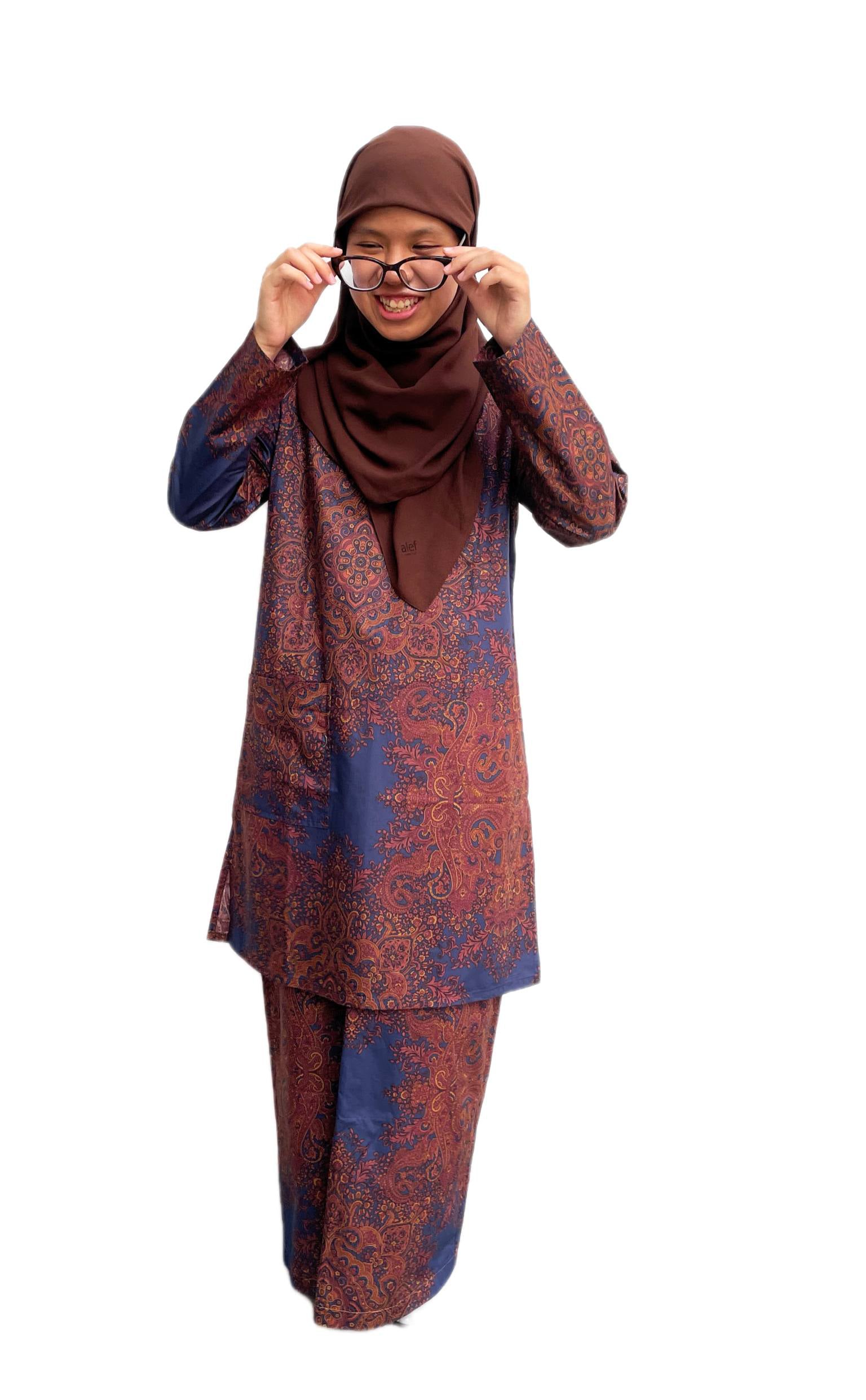 Woman wearing a patterned outfit with a hijab on a white background