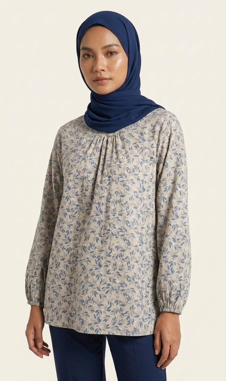 Woman wearing a floral blouse and navy hijab on a beige background