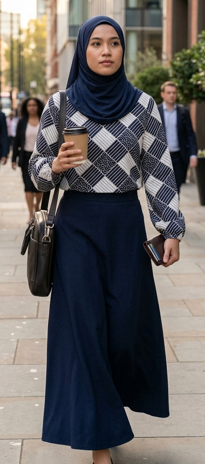 model wearing cotton printed blouse with a dark blue skirt holding coffee and carrying a bag with dark blue hijab walking in the streets to work