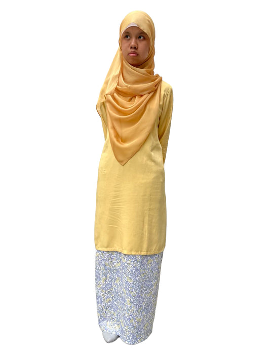 Woman wearing a yellow hijab and light yellow long bluse with a skirt floral pattern on a white background