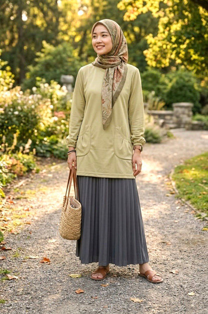 model with headscarf with a sand yellow t shirt and a skirt and a bag with a outdoors background
