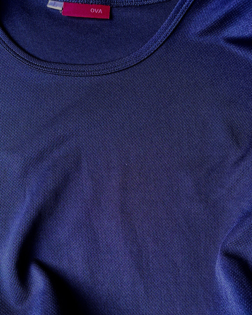 Close-up of a blue dry fit tee with a brand label.