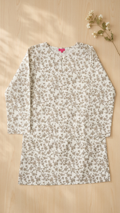 a cotton long blouse in floral bronze and white flat on a background of light brown wooden floor
