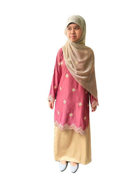 Woman wearing a pink and beige traditional outfit with a matching headscarf on a white background