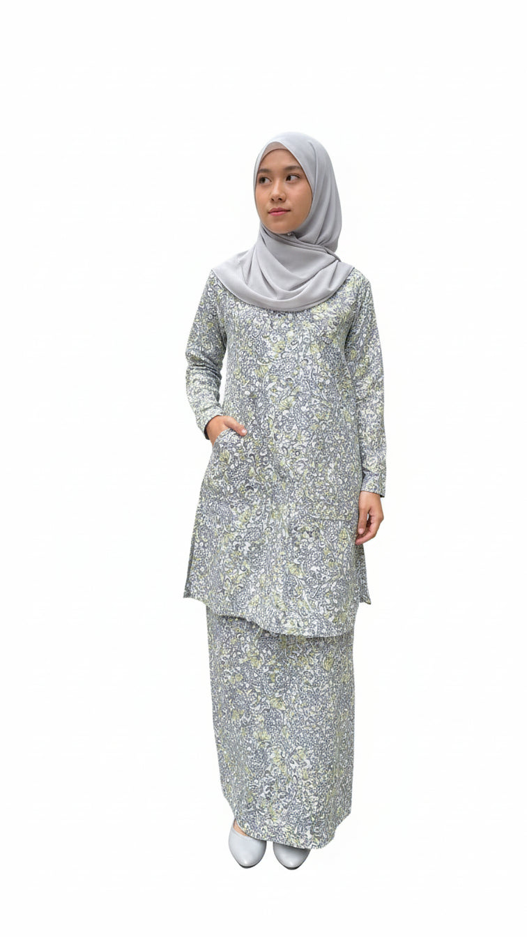 Woman wearing a floral baby blue blouse and matching skirt and hijab on a white background