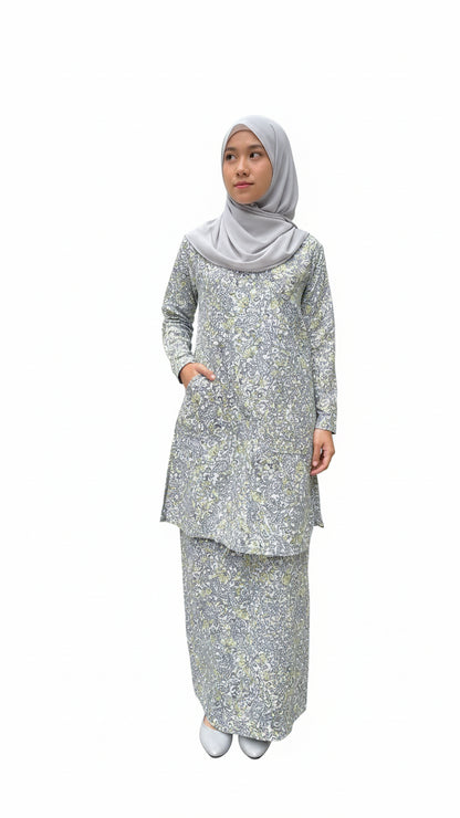 Woman wearing a floral baby blue blouse and matching skirt and hijab on a white background