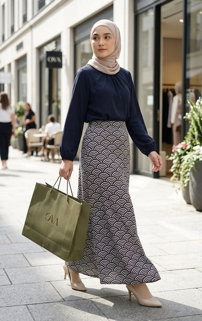 model with dark blue blouse tucked in and patterned aline skirt walking in the streets