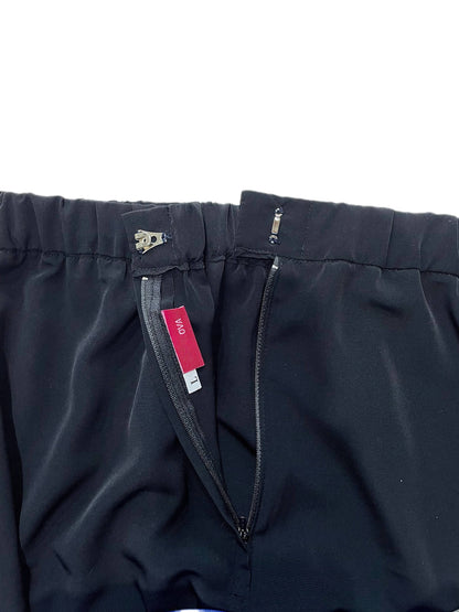 Close-up of black skirt showing the waistband, zipper, and a red interior brand tag reading 'OVA'.