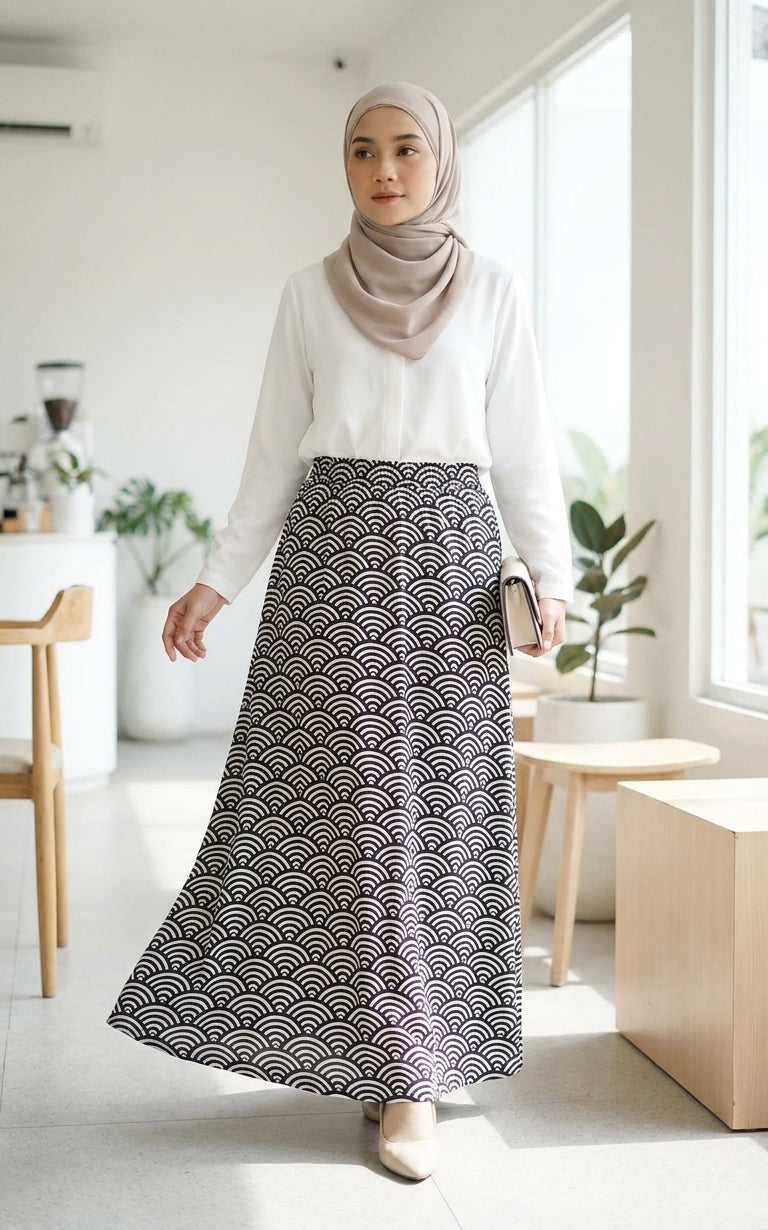 model with white blouse and printed blue skirt in a room background